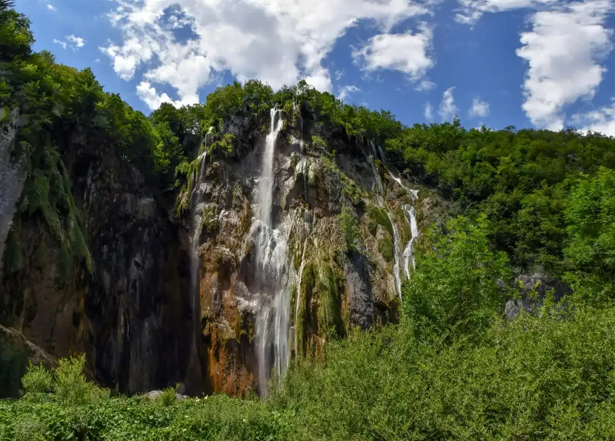 Cascadas de travertino en los Lagos de Plitvice con aguas turquesas cayendo entre la vegetación