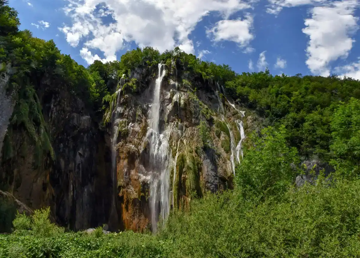 Cascadas de travertino en los Lagos de Plitvice con aguas turquesas cayendo entre la vegetación
