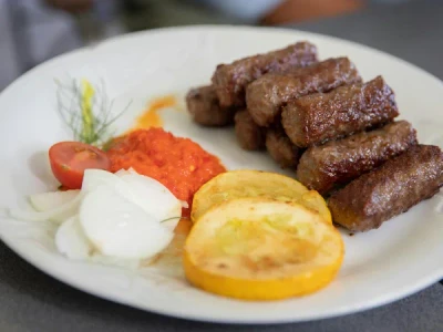 Ćevapi servidos en pan lepinja con cebolla y ajvar, comida rápida típica de Croacia