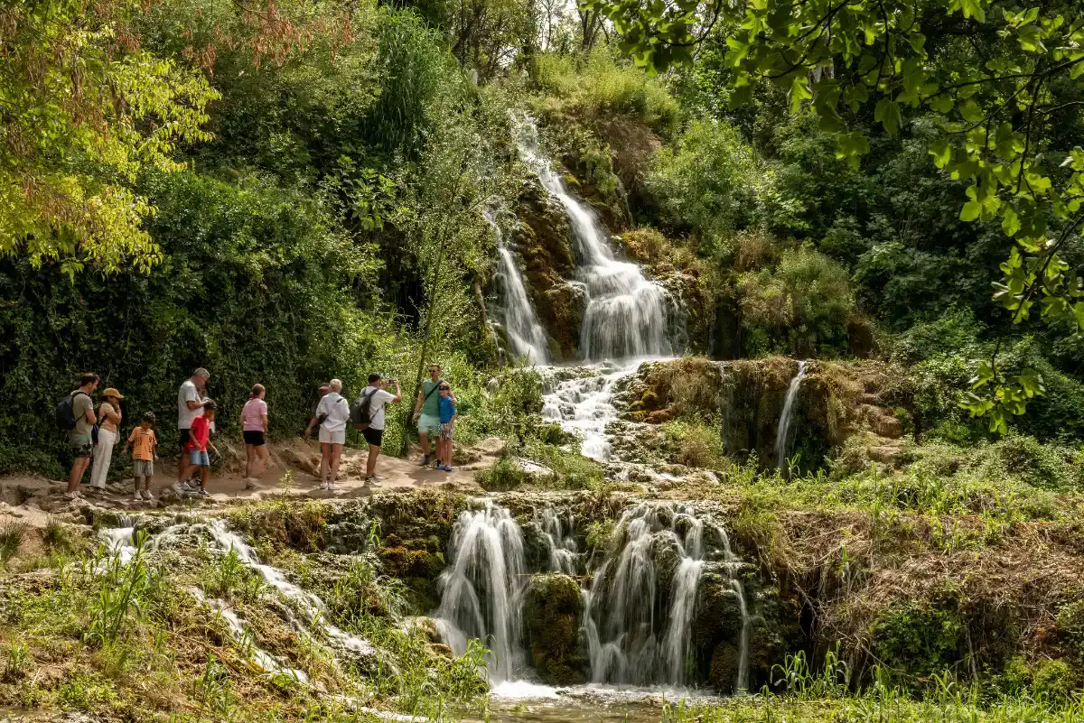 Familia visitando un parque nacional de Croacia con pasarelas de madera sobre el agua