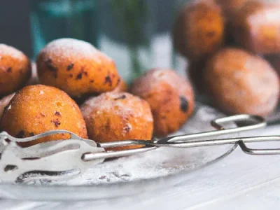 Fritule, buñuelos croatas espolvoreados con azúcar glas, postre callejero tradicional