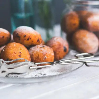 Fritule, buñuelos croatas espolvoreados con azúcar glas, postre callejero tradicional